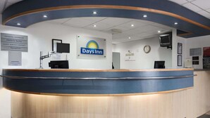 Bemandet reception hos et Days Inn hotel, med skilt til Regionsdirektør og Kontakt til Gæster.
