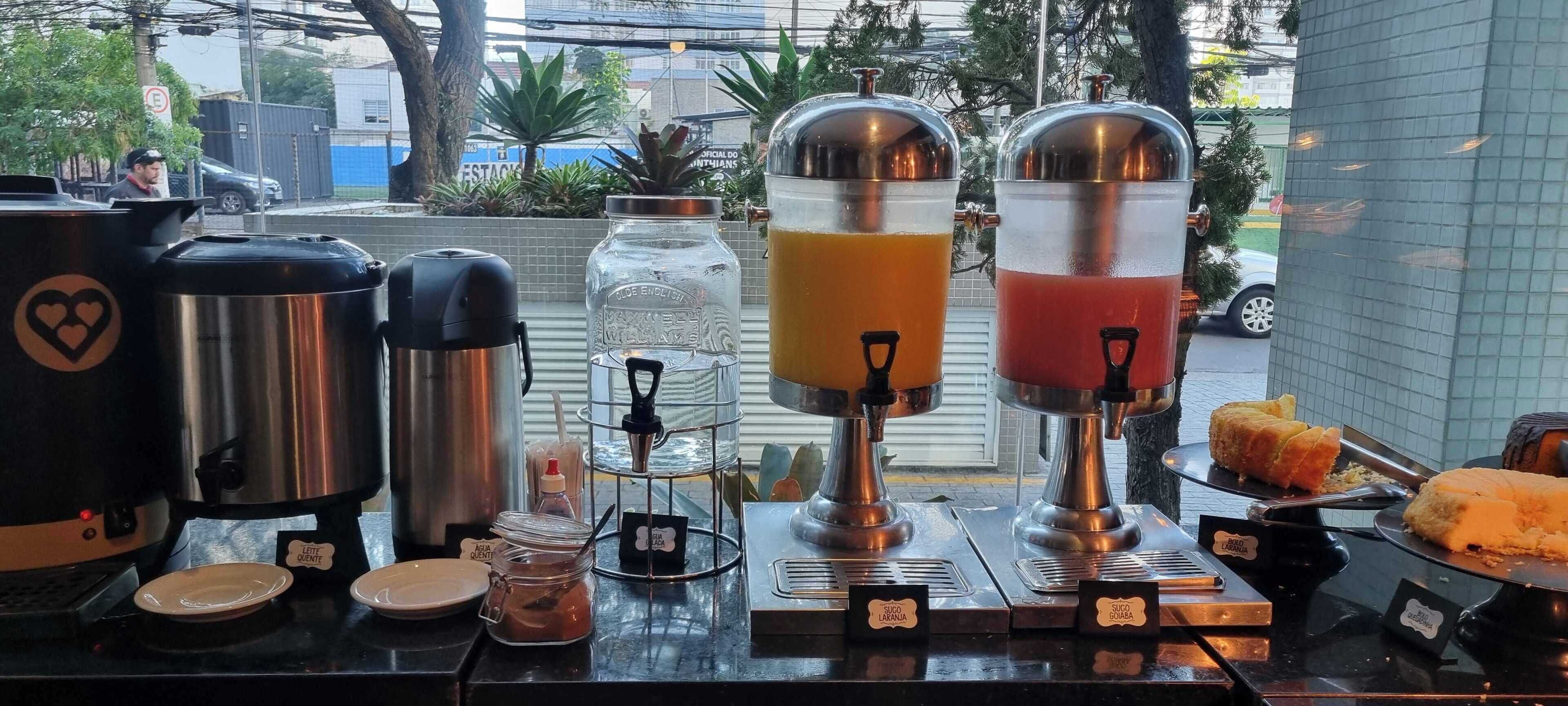 A coffee station with multiple coffee makers and a juice dispenser.