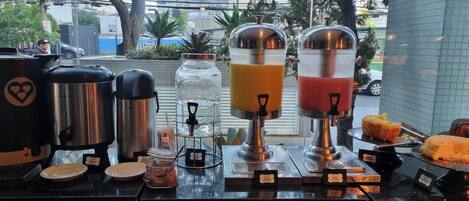 A coffee station with multiple coffee makers and a juice dispenser.