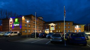 A Holiday Inn Express hotel with a parking lot and several cars parked in front.