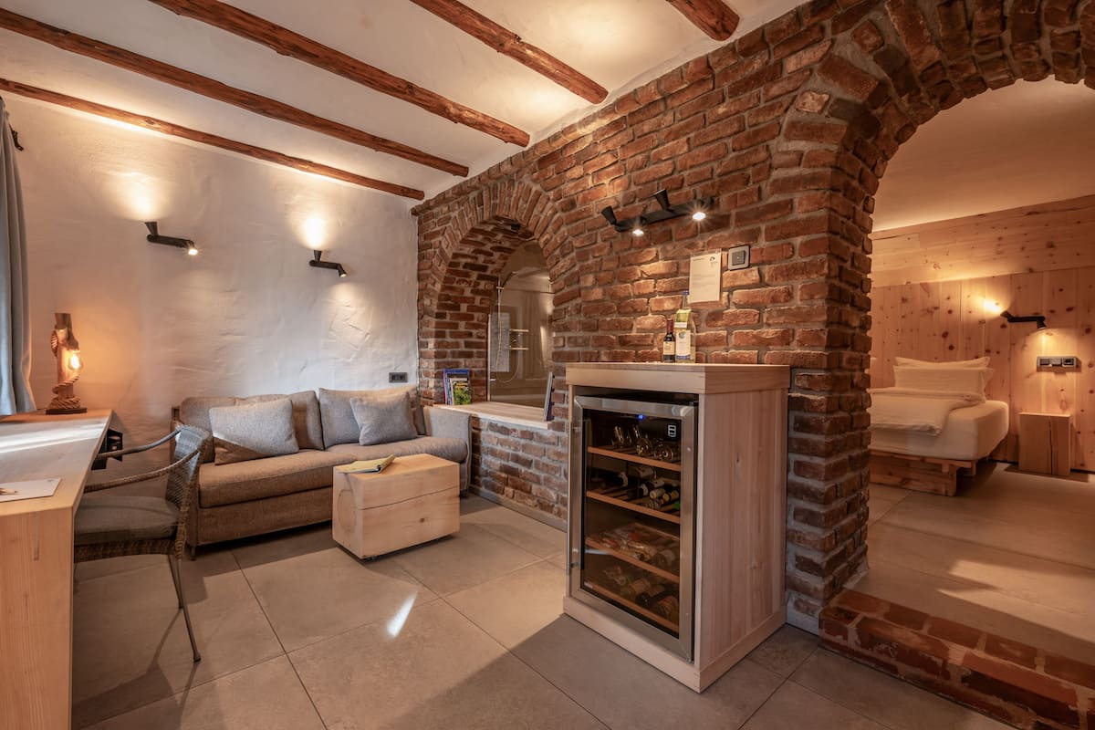 A cozy living room with a brick fireplace, a wooden coffee table, and a comfortable sofa.