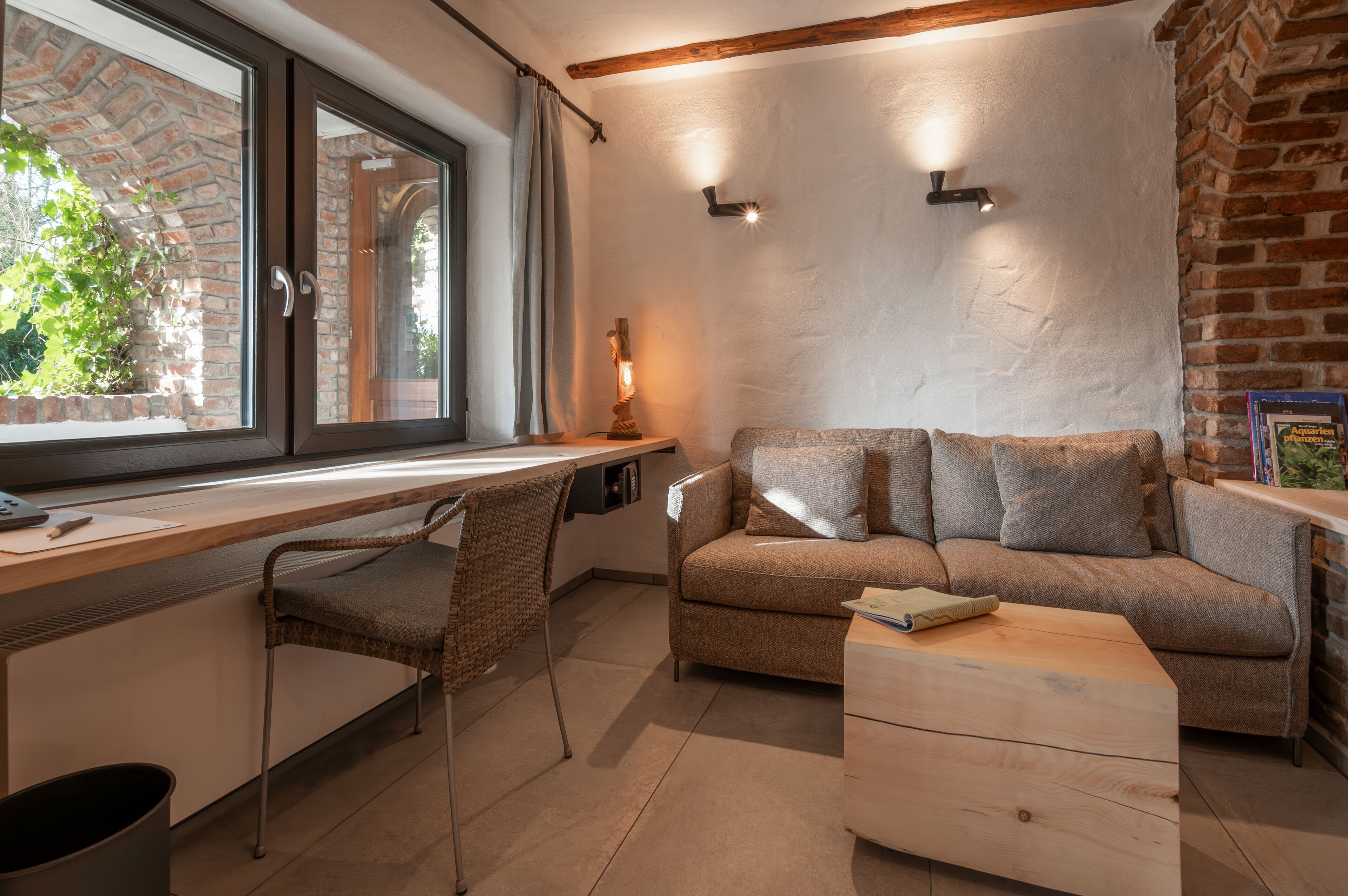 A cozy living room with a wooden desk, a comfortable sofa, and a small coffee table.