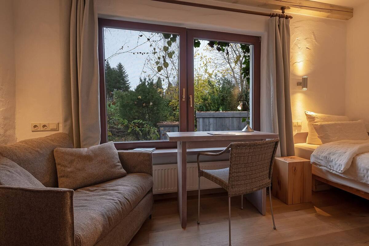 A cozy room with a bed, a desk, and a chair.