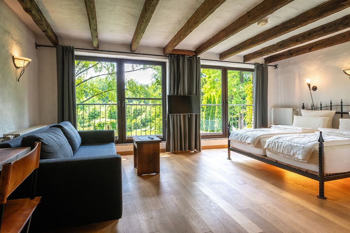 A bedroom with a wooden bed frame, a sofa, and a nightstand.