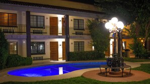 A hotel courtyard with a swimming pool, a fountain, and a well-lit entrance. - Hotel Colonial Ciudad Juarez (Ciudad Juárez)