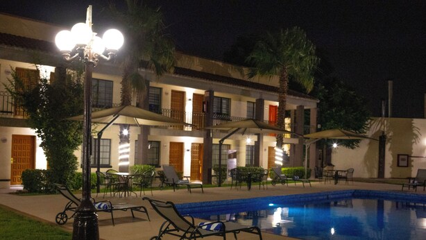A hotel with a swimming pool, lounge chairs, and outdoor seating. - Hotel Colonial Ciudad Juarez (Ciudad Juárez)