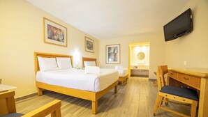 A hotel room with a double bed, bedside tables, a desk with a chair, a television mounted on the wall, and artwork on the walls. - Hotel Colonial Ciudad Juarez (Ciudad Juárez)