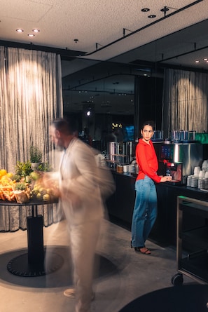 Un espace bar moderne avec un comptoir, un choix de boissons et une présentation de fruits.