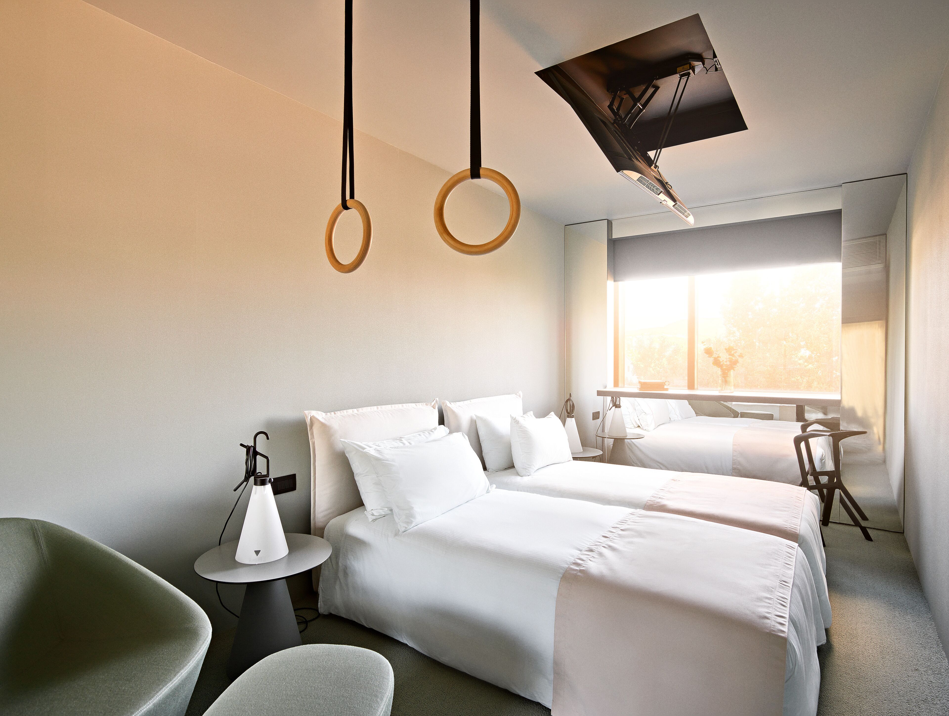 A hotel room with two beds, a desk, and a chair.