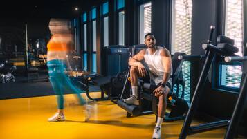 A gym with exercise equipment and large windows.