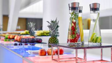 Una mesa de buffet con diversas frutas y bebidas.