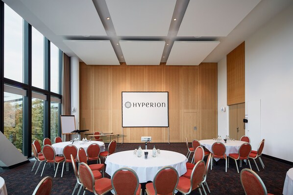 Un salón de conferencias con una pantalla grande que muestra