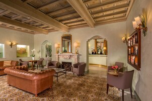 A spacious lobby with a fireplace, leather sofa, and armchairs.