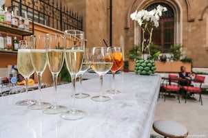 A bar area with several glasses of beverages on a marble counter.