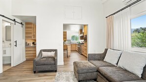 A modern living room with a grey sofa, a grey armchair, and a wooden floor. - Pacific Crest Hotel Santa Barbara (Santa Barbara)