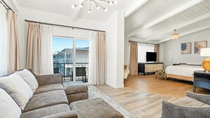 A spacious bedroom with a large bed, a desk, and a television. There is a balcony with curtains and a view of buildings. - Pacific Crest Hotel Santa Barbara (Santa Barbara)