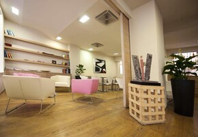 Un interno moderno con una reception, una zona salotto e una libreria.