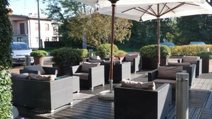 An outdoor seating area with wicker furniture and a large umbrella.