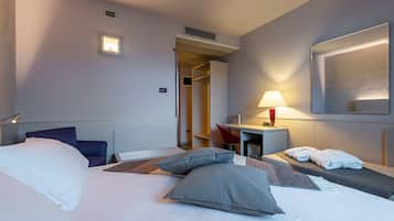 Ein Hotelzimmer mit Bett, Nachttisch, Lampe und Spiegel.