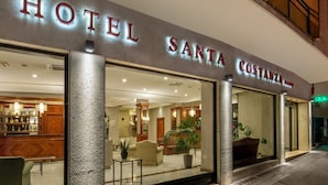 Exterior del Hotel Santa Costanza, con una zona de bar visible en el interior.