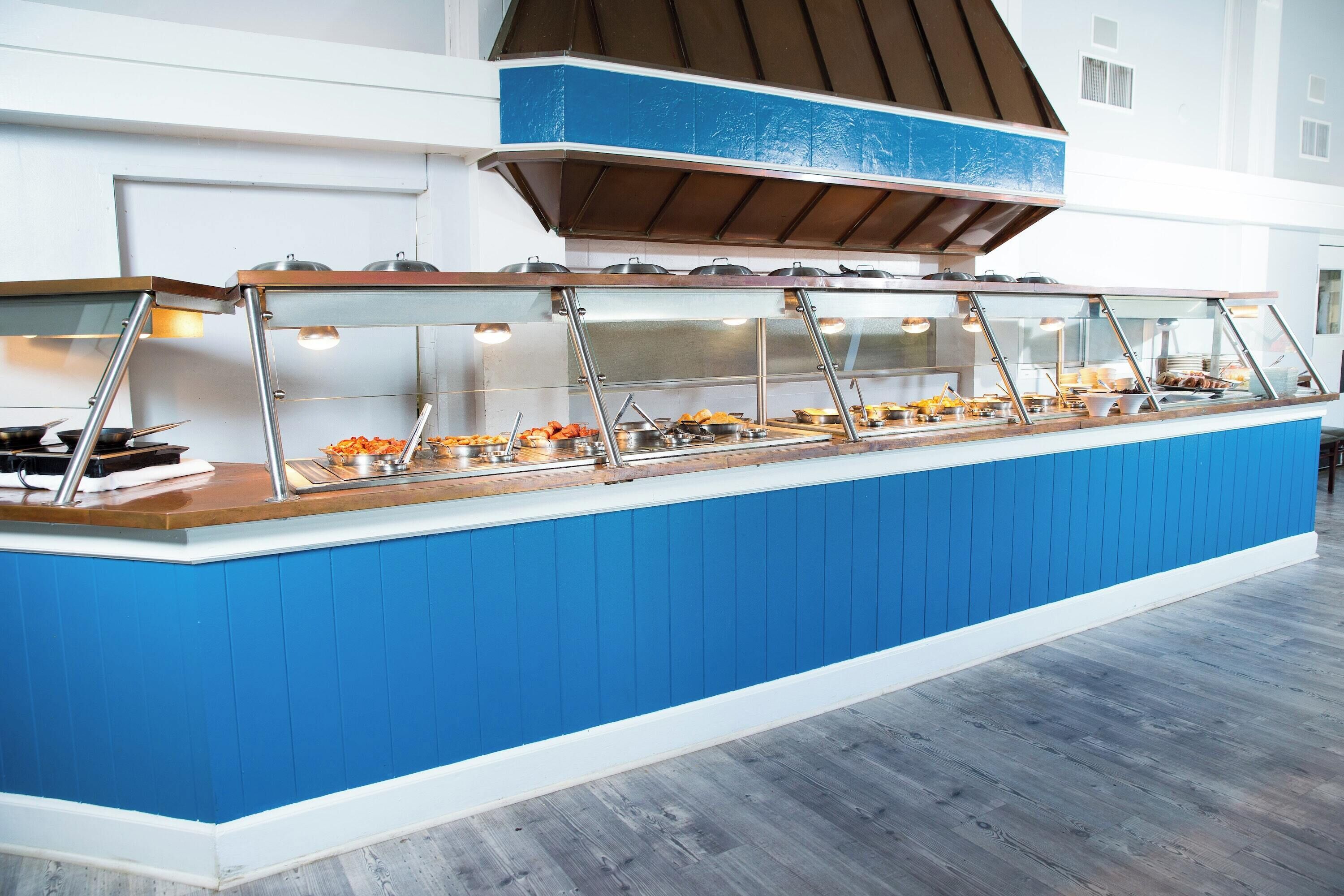 A buffet setup with multiple serving stations, a blue and white color scheme, and a modern industrial design.