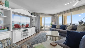 Relax in a spacious living area with a sofa, armchairs, and dining table, perfect for socializing or enjoying a meal.