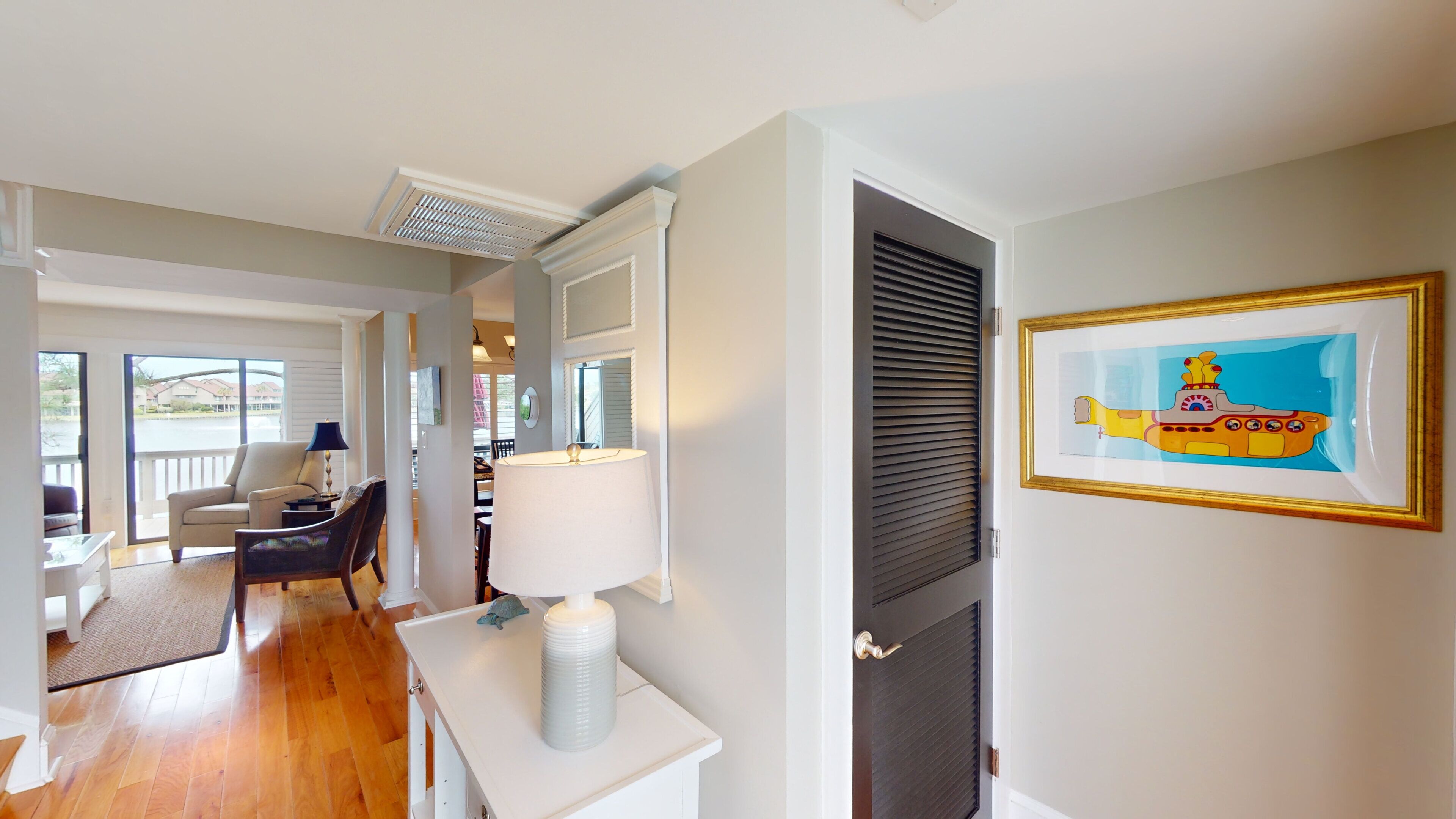Habitación de hotel con comedor, un ventanal grande, chimenea y un cuadro en la pared.