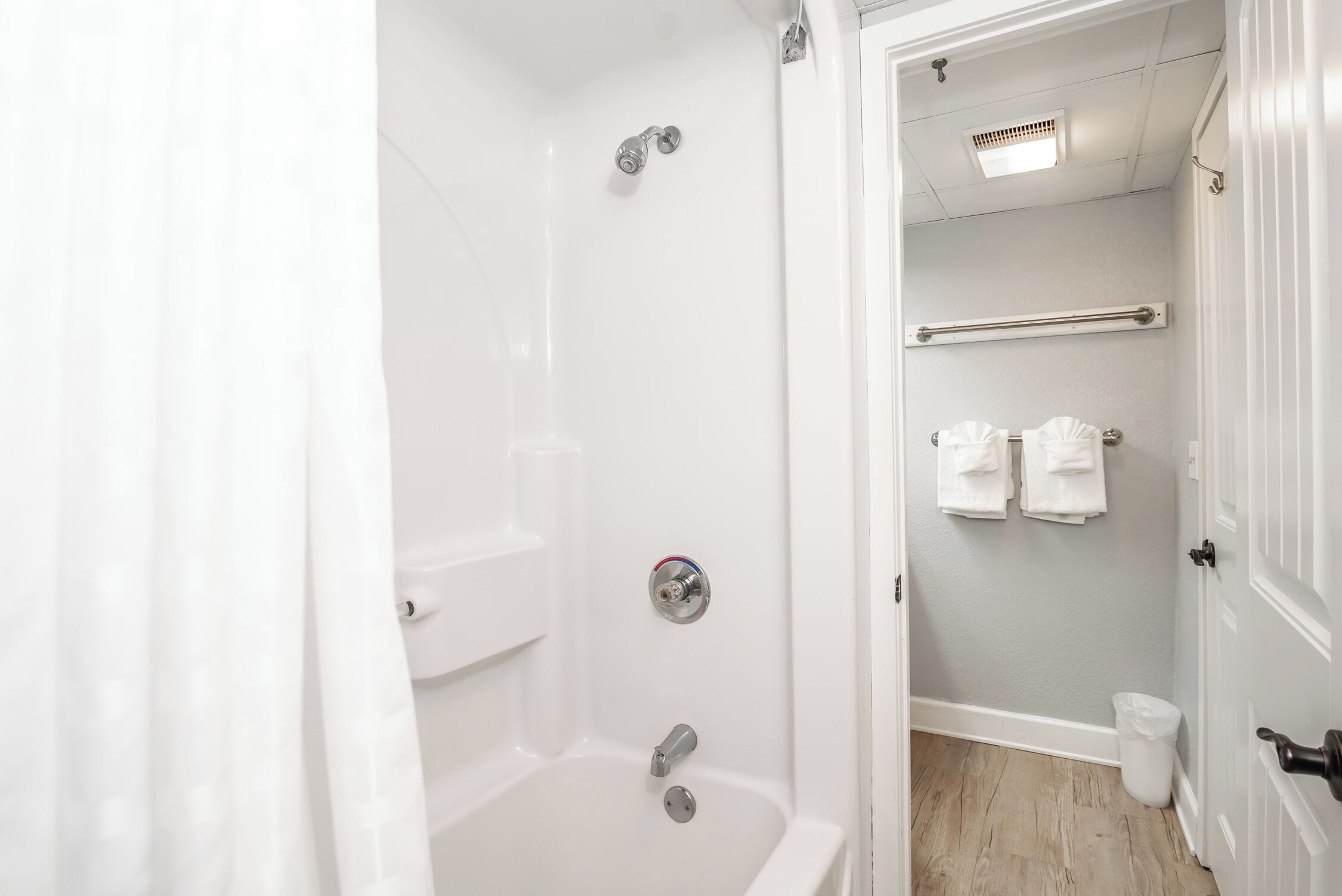 A bathroom with a shower, toilet, and towel rack.