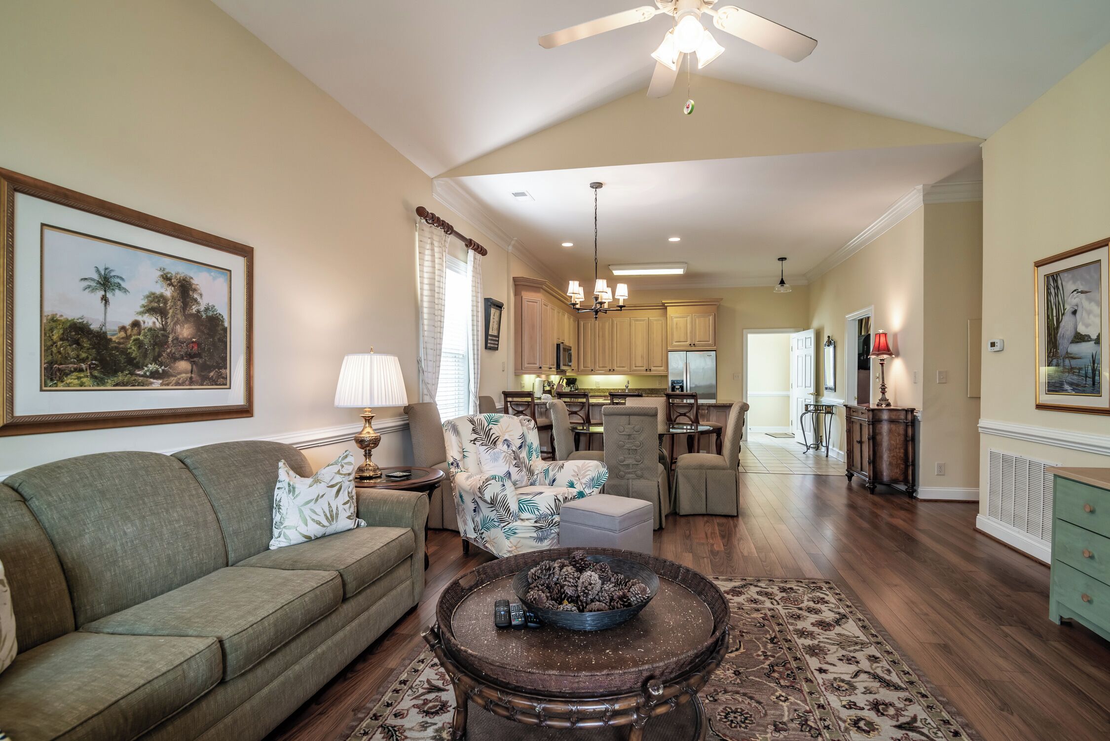 A spacious living room with a sofa, a coffee table, and a dining area with chairs.