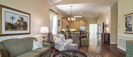 A spacious living room with a sofa, a coffee table, and a dining area with chairs.