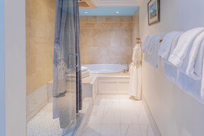 A modern bathroom with a glass shower enclosure, a bathtub, and a sink.