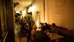 A restaurant with outdoor seating, a fire pit, and a sign indicating it is a hotel restaurant. - Hotel Northbridge (Perth)