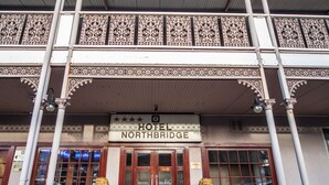 A hotel entrance with a sign reading "HOTEL NORTHBRIDGE," two golden lion statues, and a covered entrance area with intricate designs. - Hotel Northbridge (Perth)