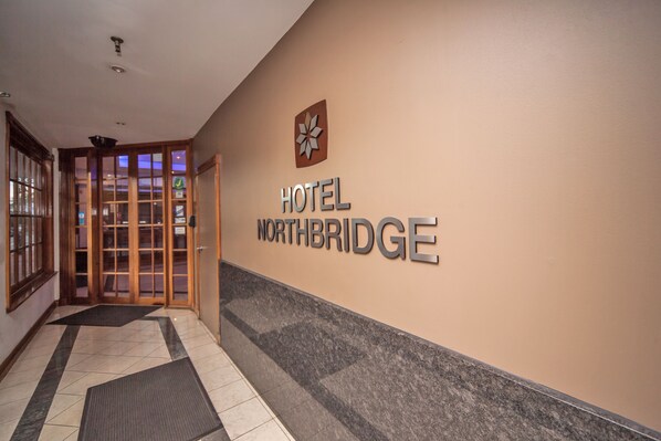 A hotel entrance with a sign reading "HOTEL NORTHBRIDGE" and a logo above it.