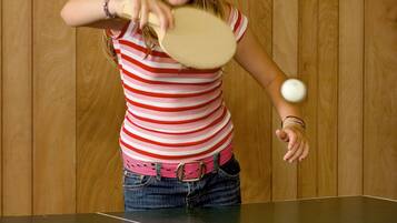 Iemand speelt tafeltennis in een kamer met houten wanden.