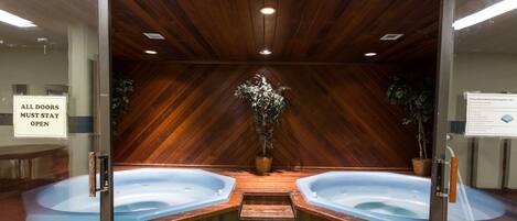 A spa area with two hot tubs and a wooden ceiling.