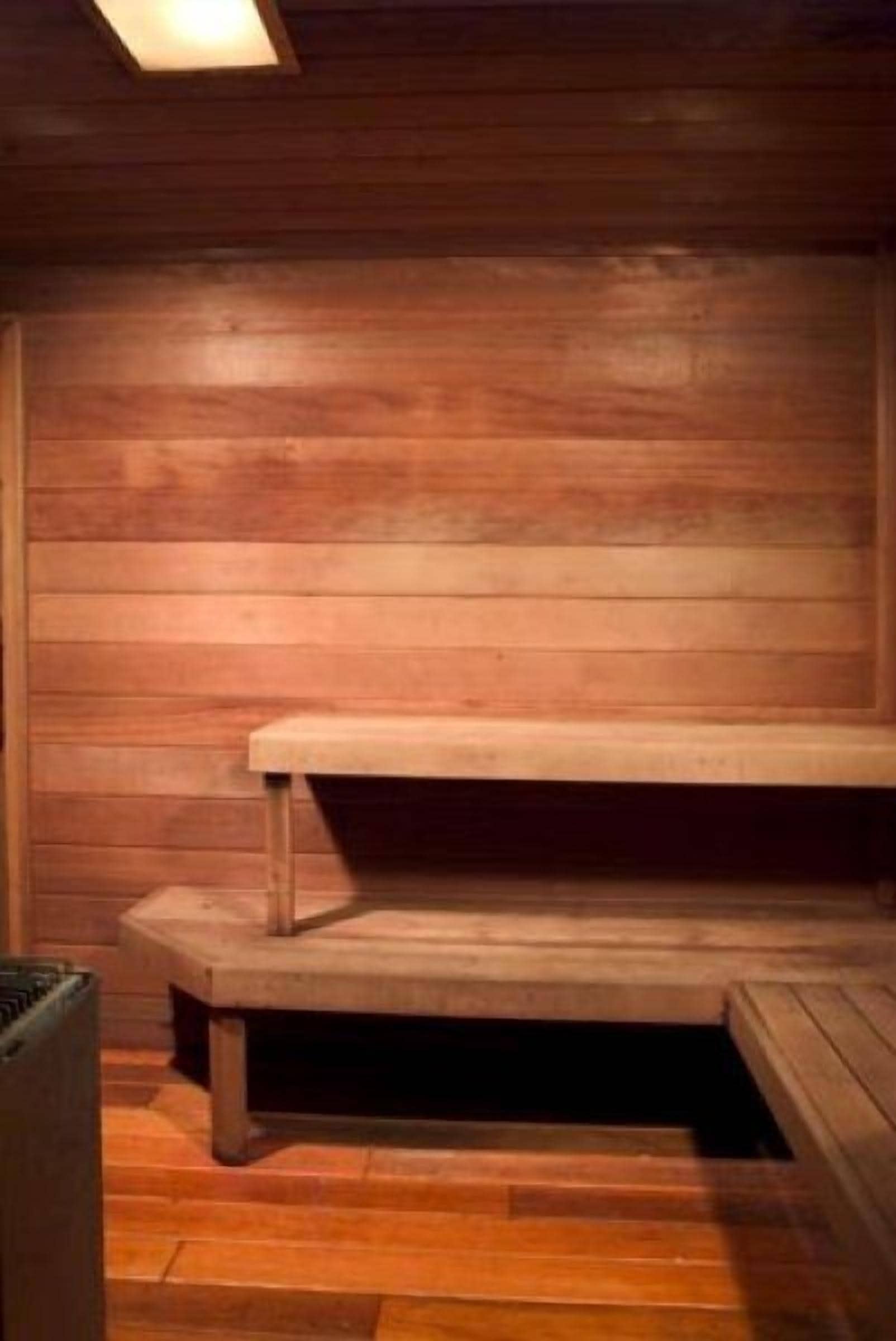 Una sauna de madera con bancos y un asiento.
