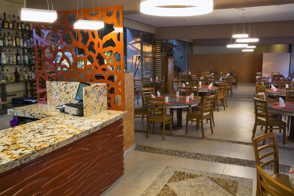 Un restaurant amb zona de bar, diverses taules i seients.