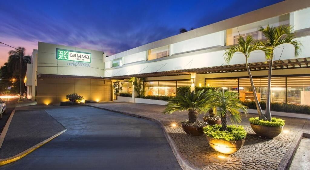 A hotel with a modern design, a signboard, and a well-lit entrance.