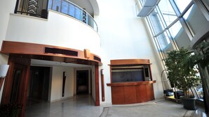 A spacious lobby with a reception desk, a staircase, and a large window providing natural light. - Ankara Hotel Midi (Ankara)