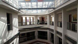 A multi-level atrium with a glass ceiling, multiple balconies, and a central open space. - Ankara Hotel Midi (Ankara)