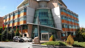 A modern hotel with a curved facade, large glass windows, and a prominent entrance. - Ankara Hotel Midi (Ankara)