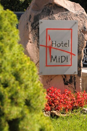 A sign for Hotel MiDi mounted on a large rock with a red border. - Ankara Hotel Midi (Ankara)