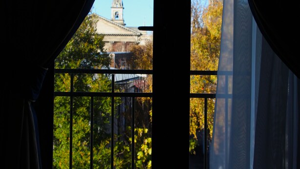 A room with a view of a building through a window with curtains. - Motel on York (Dunedin)