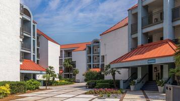 A hotel courtyard with a central open space, surrounded by multi-story buildings with balconies and a red roof.