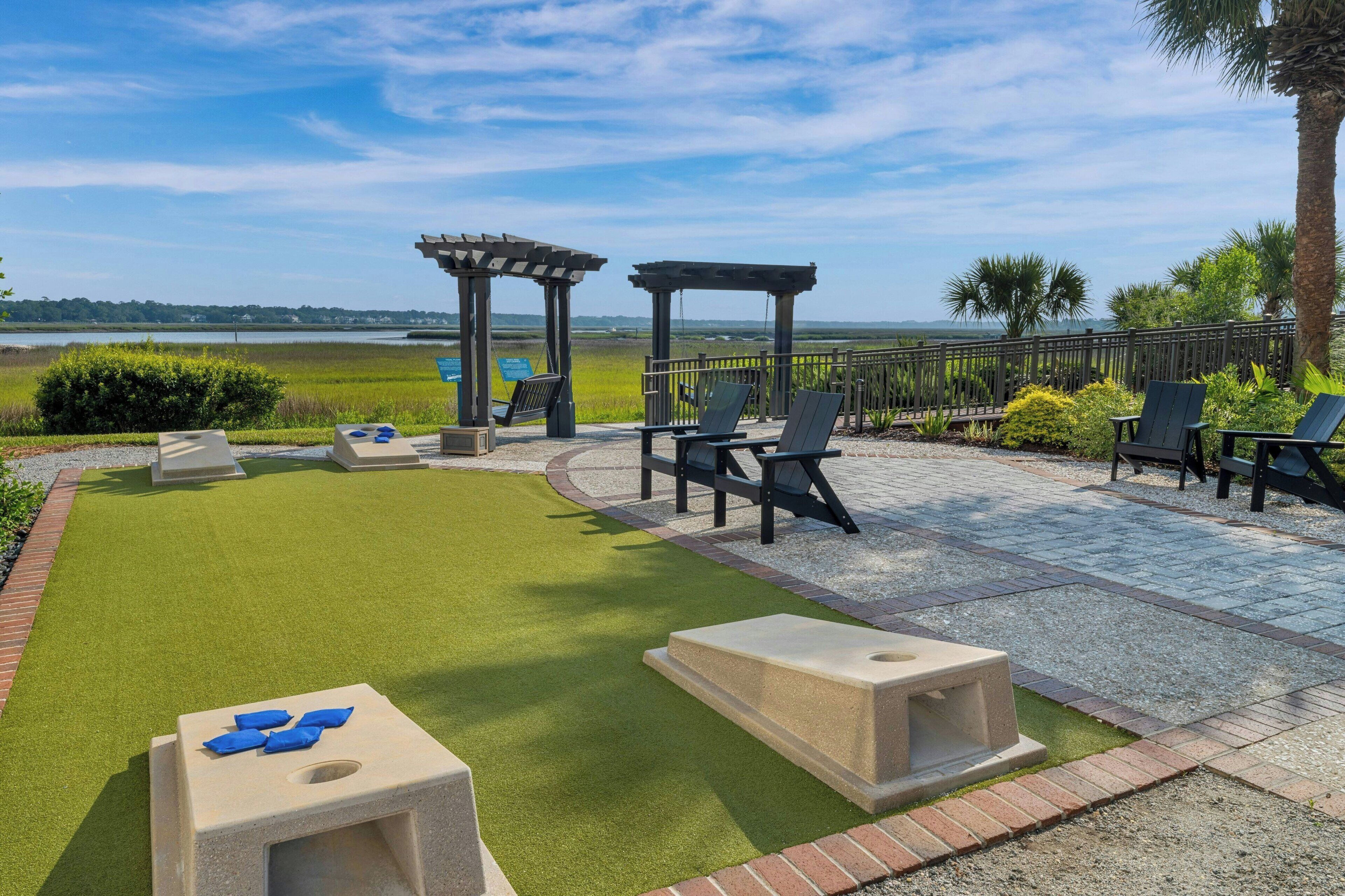 An outdoor patio area with seating, a pergola, and a view of the water.