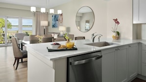A modern kitchen with a central island, a dining area with a view, and a large mirror.