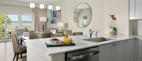 A modern kitchen with a central island, a dining area with a view, and a large mirror.