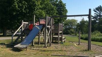 A playground with a slide and climbing structures.