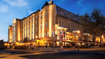 Experience the classic charm of this historic hotel, featuring a grand corner entrance and elegant facade with columns and intricate window designs.
